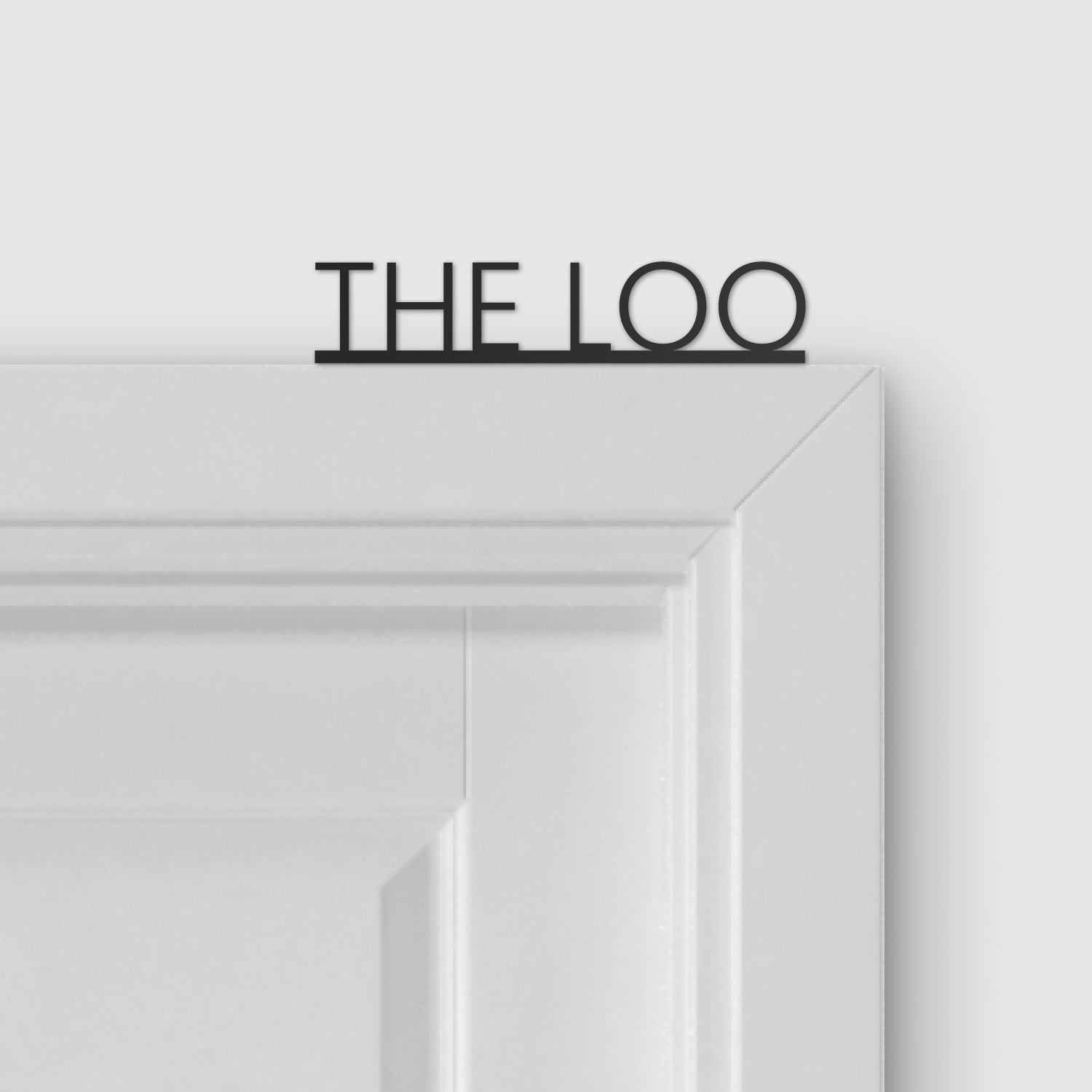 The Loo Door Topper displayed above a door
